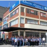 Large group of people in uniform standing in front of a multi-story brick building with 