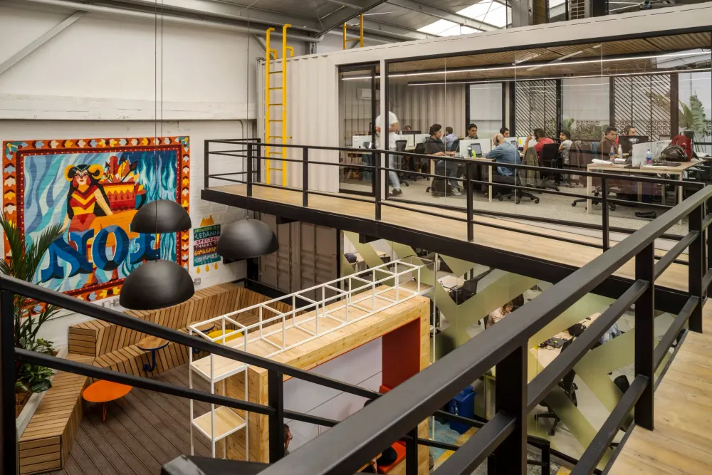Modern open-plan office space with multiple levels and collaborative work areas.